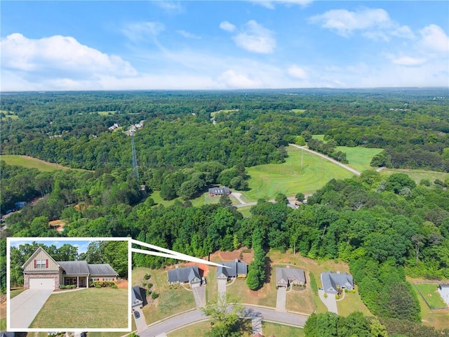 drone / aerial view featuring a wooded view