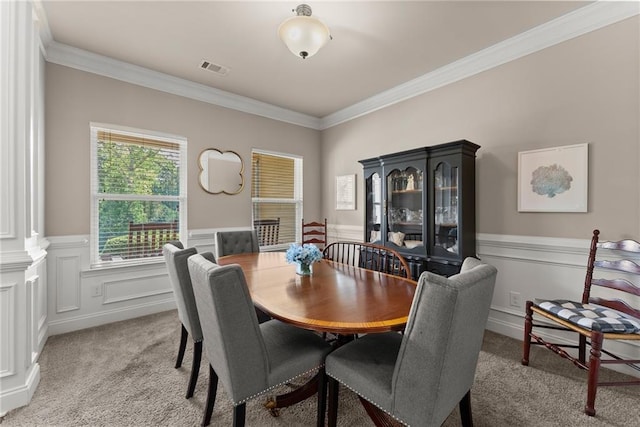 dining room with ornamental molding, visible vents, and light colored carpet