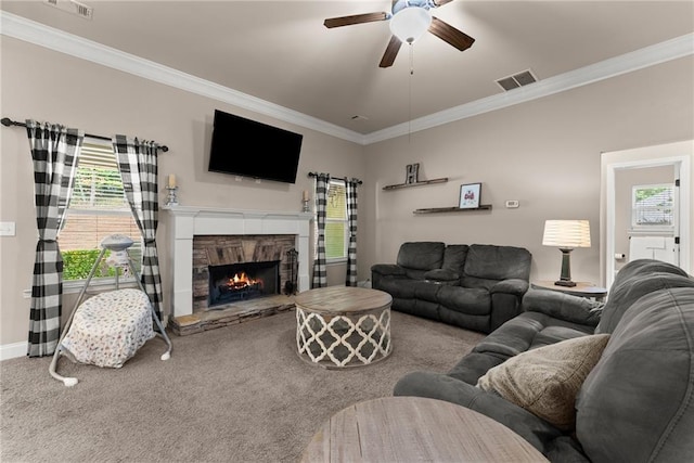 living area featuring a ceiling fan, visible vents, ornamental molding, and a healthy amount of sunlight