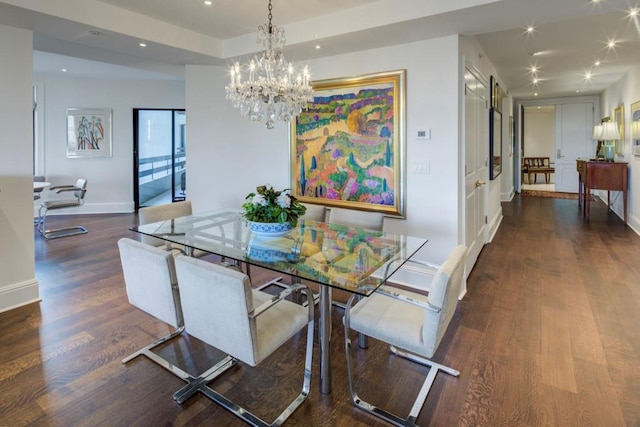 dining space with dark hardwood / wood-style flooring and an inviting chandelier