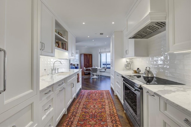 kitchen with white cabinets, electric range, sink, and custom range hood