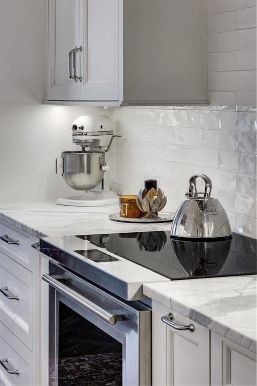 kitchen with electric range, light stone countertops, and backsplash