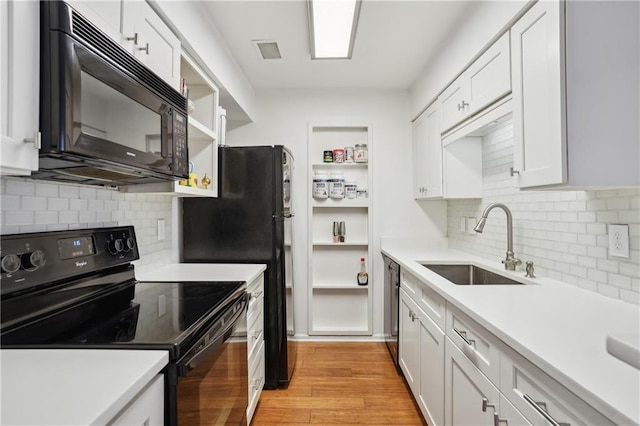 kitchen with white cabinetry, sink, black appliances, and light wood-type flooring