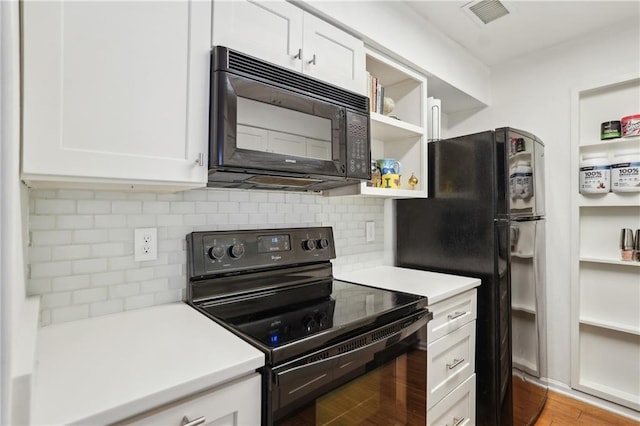 kitchen with tasteful backsplash, white cabinetry, light hardwood / wood-style flooring, and black appliances