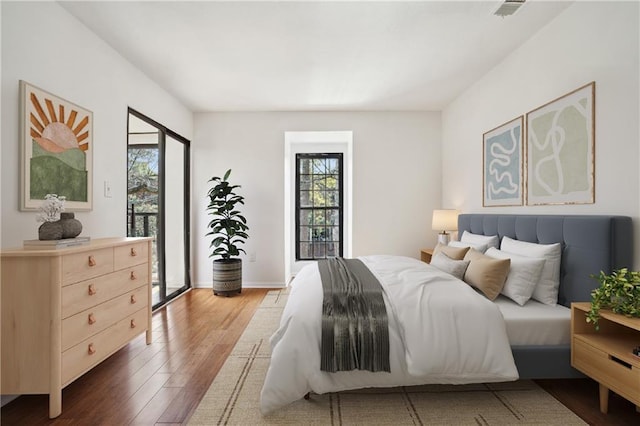 bedroom featuring wood-type flooring and access to exterior