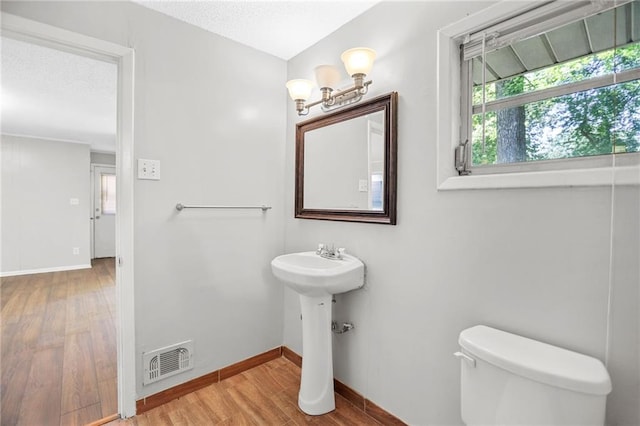 2215 Springdale Rd SW, Atlanta, GA 30315 - half bath with toilet, wood finished floors, baseboards, a textured ceiling, and a sink