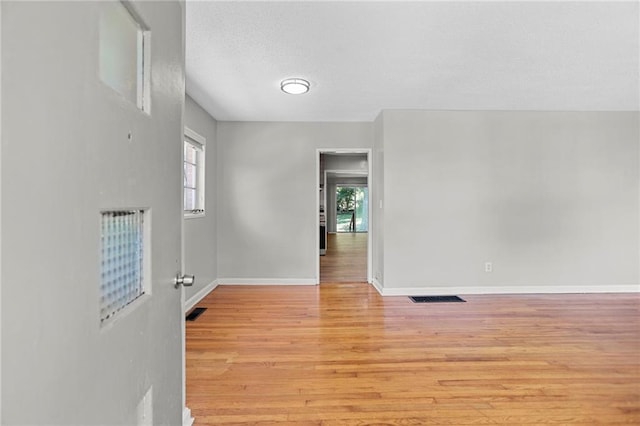 2215 Springdale Rd SW, Atlanta, GA 30315 - spare room featuring light wood finished floors, baseboards, and a textured ceiling