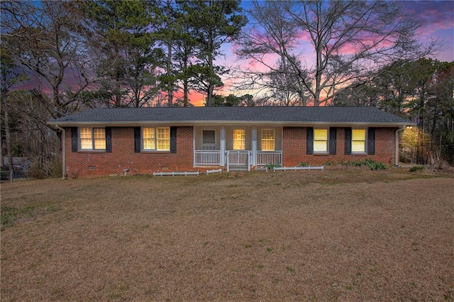 single story home featuring a front yard, crawl space, brick siding, and covered porch