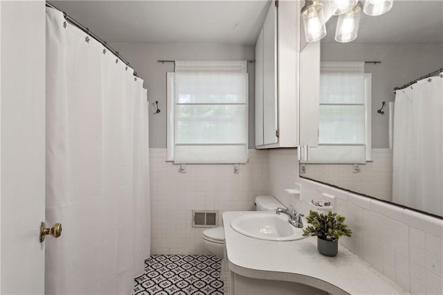 205 Glencourtney Dr, Sandy Springs, GA 30328 - full bath with tile walls, toilet, vanity, tile patterned floors, and a wainscoted wall