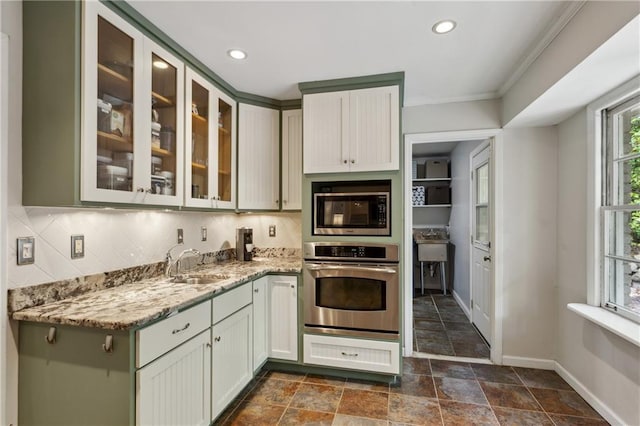 205 Glencourtney Dr, Sandy Springs, GA 30328 - kitchen with stainless steel appliances, a sink, baseboards, decorative backsplash, and light stone counters