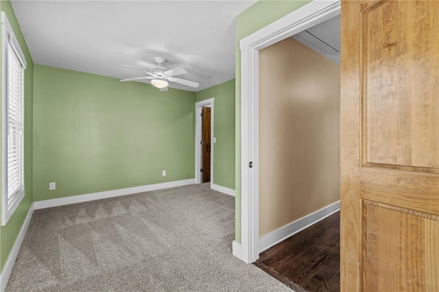 carpeted spare room with baseboards and a ceiling fan