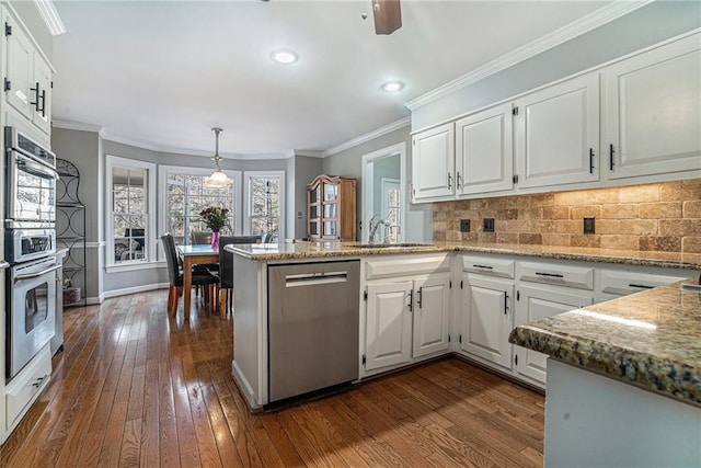 kitchen featuring white cabinetry, kitchen peninsula, stainless steel dishwasher, and sink