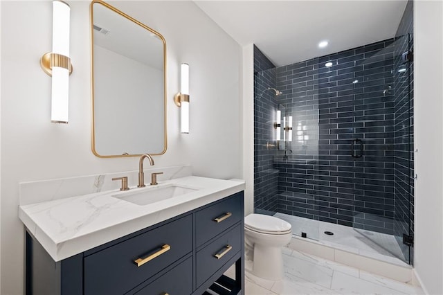 bathroom with vanity, toilet, and tiled shower