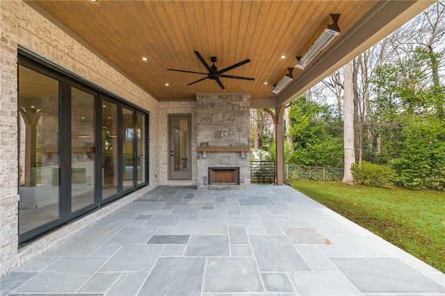 view of patio / terrace with ceiling fan and an outdoor stone fireplace