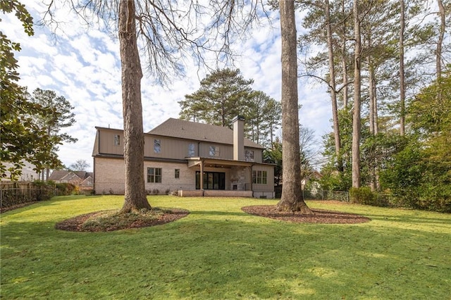 rear view of house featuring a lawn