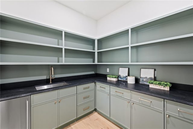 kitchen featuring gray cabinets, sink, dark stone countertops, and light hardwood / wood-style floors