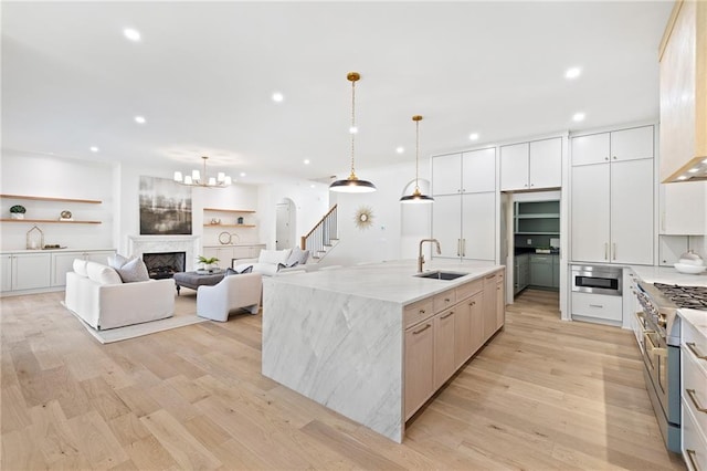 kitchen with white cabinetry, sink, decorative light fixtures, and a spacious island