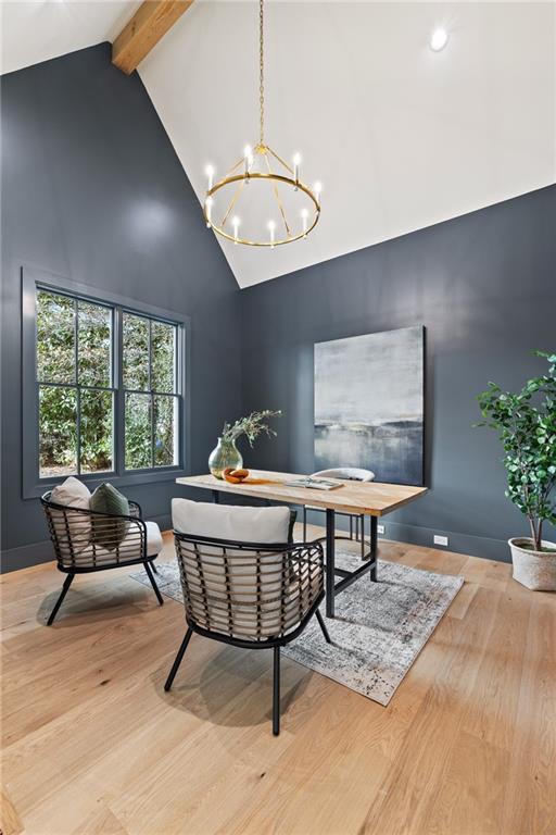 interior space featuring beam ceiling, high vaulted ceiling, a chandelier, and light wood-type flooring