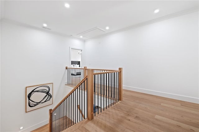 hallway with ornamental molding and light hardwood / wood-style floors