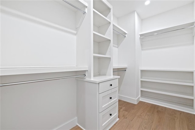 walk in closet with light hardwood / wood-style floors