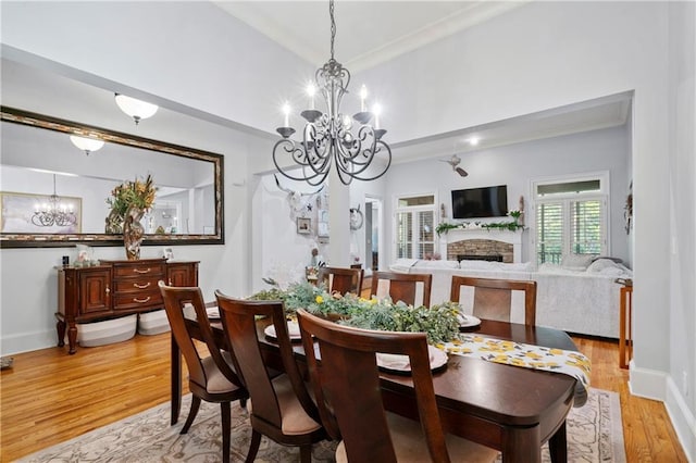 11 York Trce, Cartersville, GA 30121 - dining room with a chandelier, a stone fireplace, light wood finished floors, crown molding, and baseboards