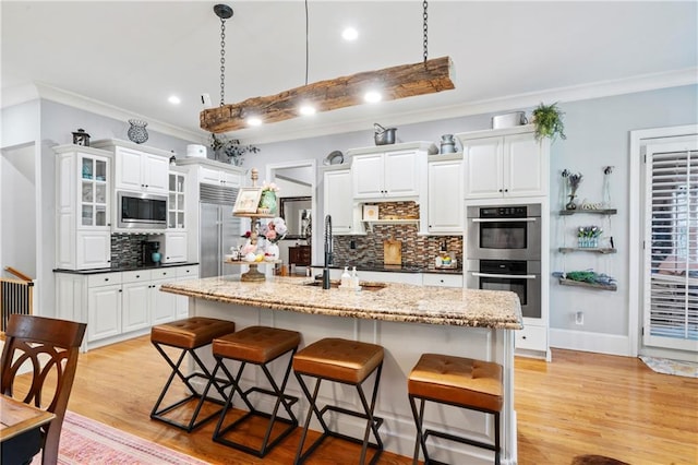 11 York Trce, Cartersville, GA 30121 - kitchen with built in appliances, a sink, a chandelier, a breakfast bar, and white cabinetry