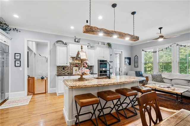 11 York Trce, Cartersville, GA 30121 - kitchen with stainless steel appliances, a sink, light wood-style flooring, dark brown cabinetry, and decorative backsplash