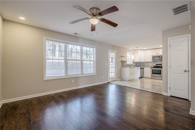 interior space featuring ceiling fan, sink, and light wood-type flooring