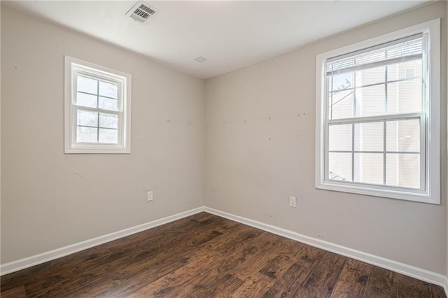 unfurnished room with a wealth of natural light and dark hardwood / wood-style floors