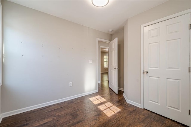 unfurnished bedroom with dark wood-type flooring