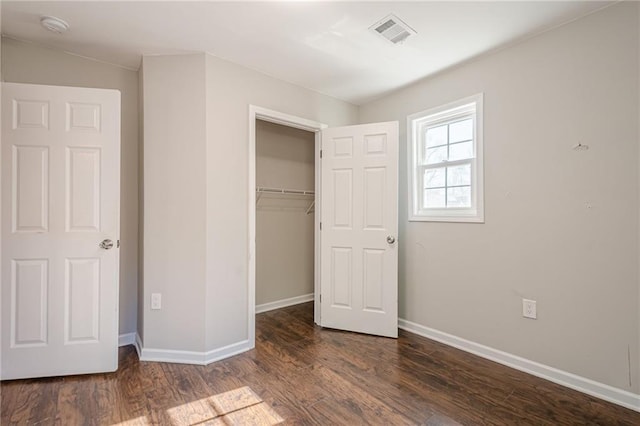 unfurnished bedroom featuring a closet and dark wood-type flooring