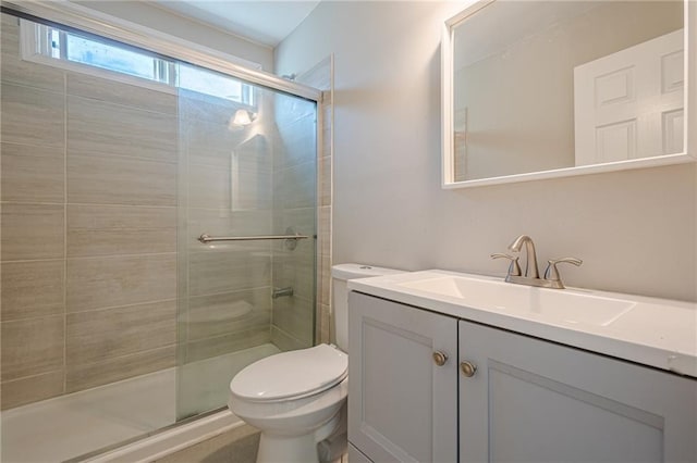 bathroom featuring toilet, a shower with door, and vanity