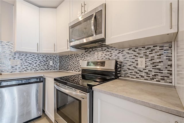 kitchen featuring decorative backsplash, white cabinets, and stainless steel appliances