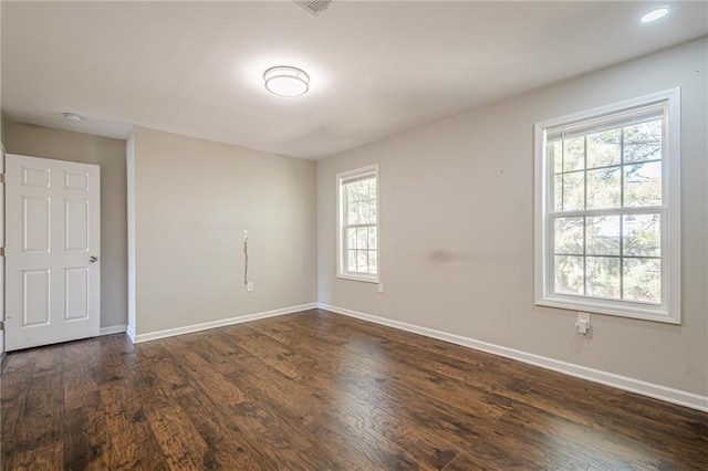 unfurnished room with dark wood-type flooring