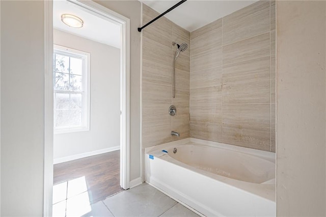 bathroom featuring tiled shower / bath combo and tile patterned floors