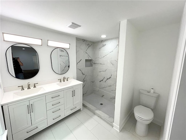 bathroom featuring vanity, toilet, and tiled shower