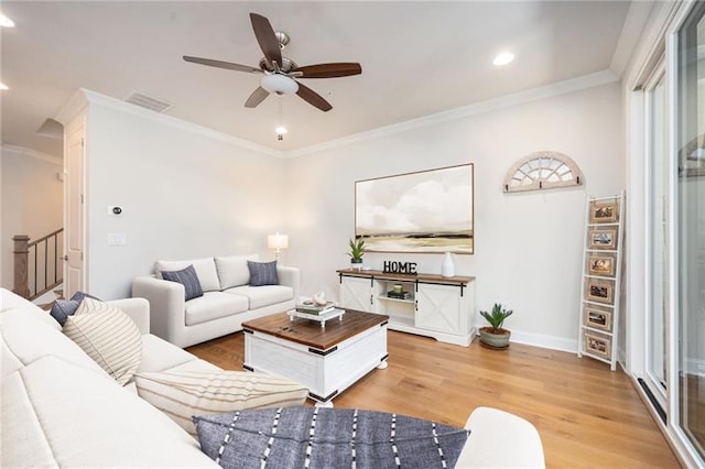 living room featuring light wood finished floors, baseboards, stairway, crown molding, and recessed lighting