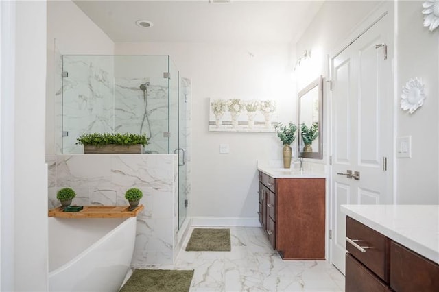 bathroom featuring marble finish floor, a marble finish shower, a freestanding bath, vanity, and baseboards