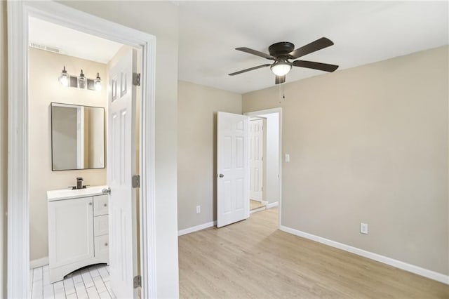 interior space featuring ceiling fan, vanity, and hardwood / wood-style floors