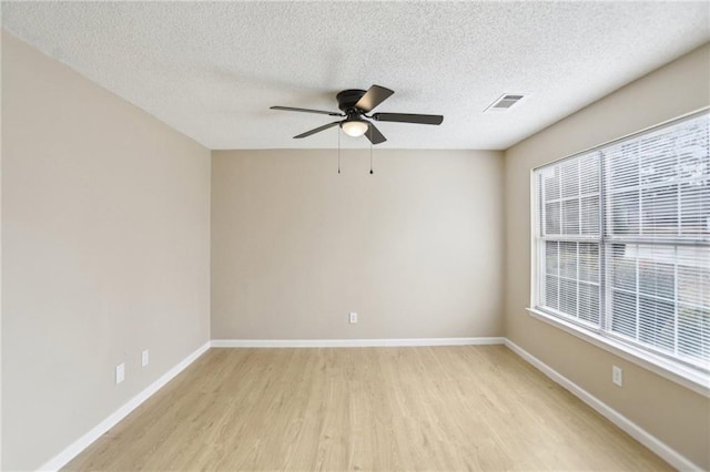 unfurnished room featuring ceiling fan, light hardwood / wood-style flooring, and a textured ceiling