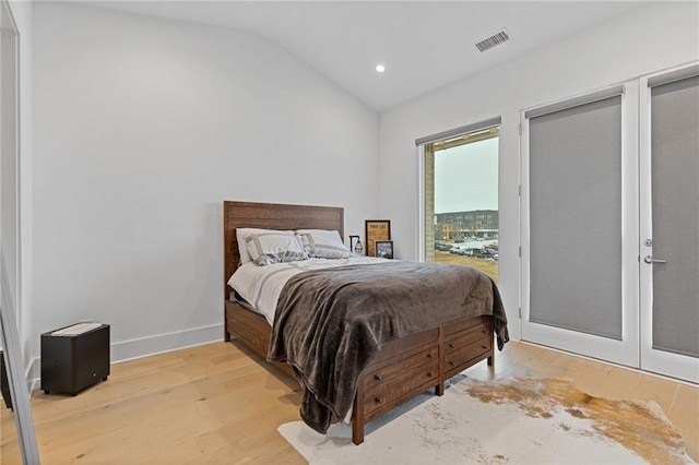 bedroom with light hardwood / wood-style floors and vaulted ceiling