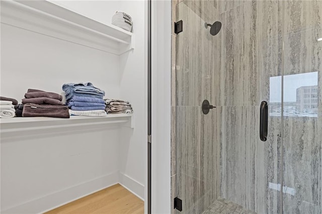 bathroom with hardwood / wood-style flooring and a shower with shower door