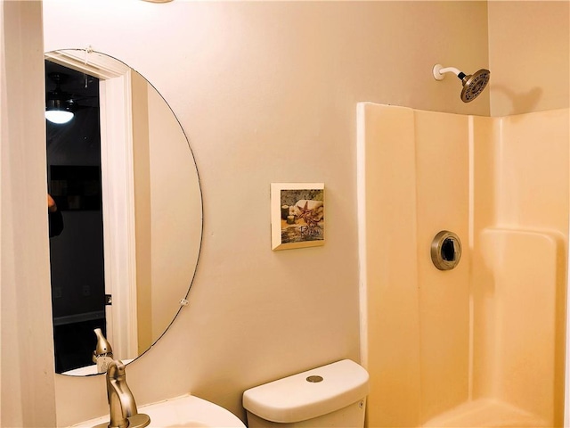 bathroom with toilet, a shower, and sink