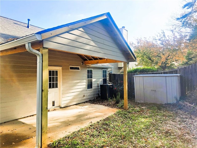 view of side of property featuring a shed, cooling unit, and a patio area