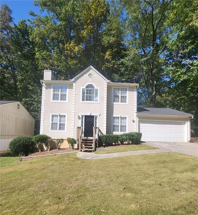 colonial-style house featuring a front yard and a garage