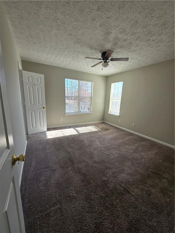 spare room featuring a textured ceiling, carpet floors, and ceiling fan