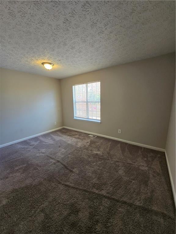 unfurnished room featuring carpet and a textured ceiling