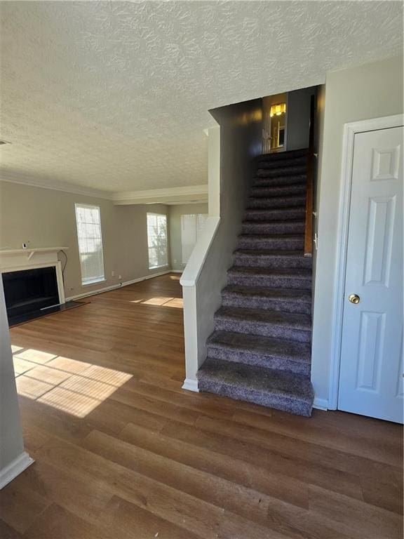 staircase with wood-type flooring and a textured ceiling