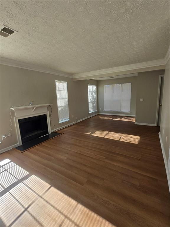 unfurnished living room with a textured ceiling, crown molding, and dark wood-type flooring