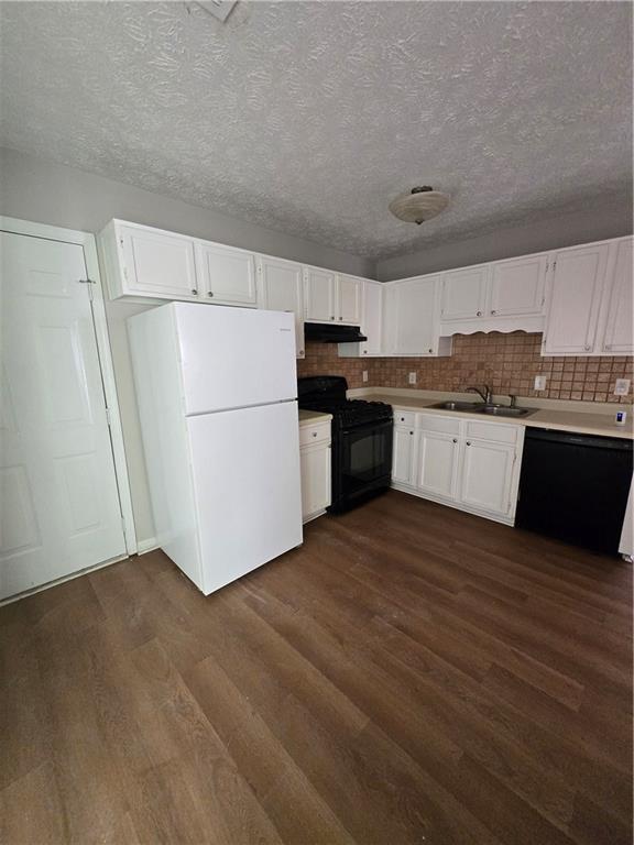 kitchen featuring tasteful backsplash, sink, black appliances, dark hardwood / wood-style floors, and white cabinetry